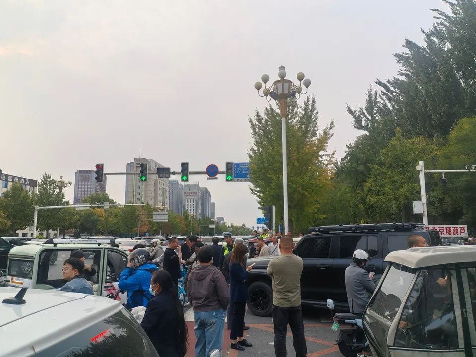 放学时段的路口：车挤车，人挤人，中间那辆越野停在斑马线上